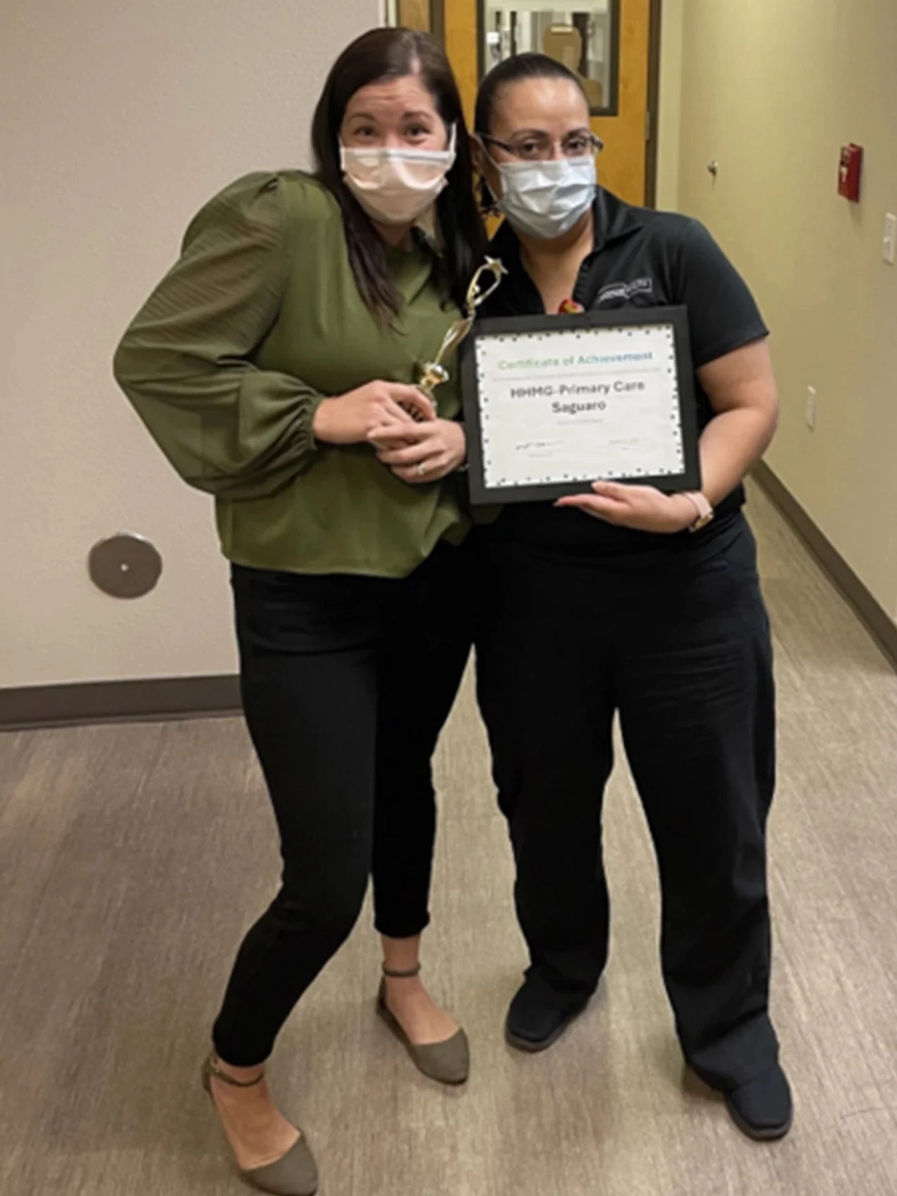 Honor Health Saguaro Primary Care Employees pose with a trophy and certificate